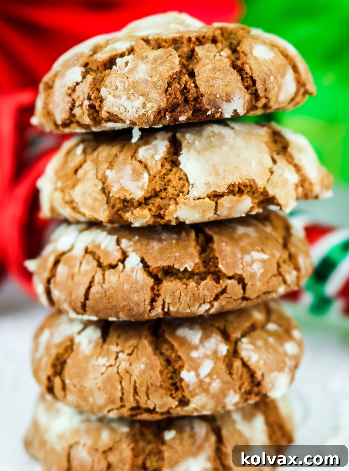Festive Gingerbread Crinkles 5 Closeup on a stack of Gingerbread Crinkle Cookies sitting on a white table in front of festive Christmas decorations.