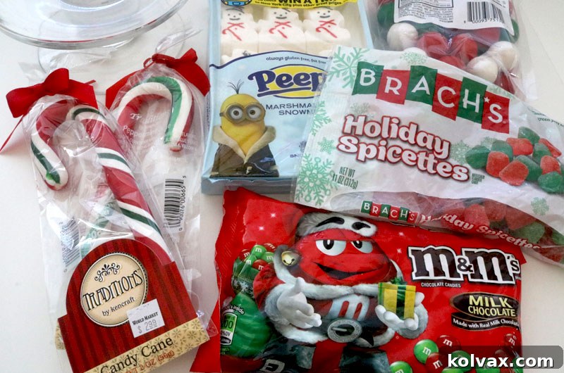 Selection of festive Christmas candies including M&M's, gumdrops, Peeps snowmen, gumballs, marshmallows, and candy canes, ready for building a DIY centerpiece.