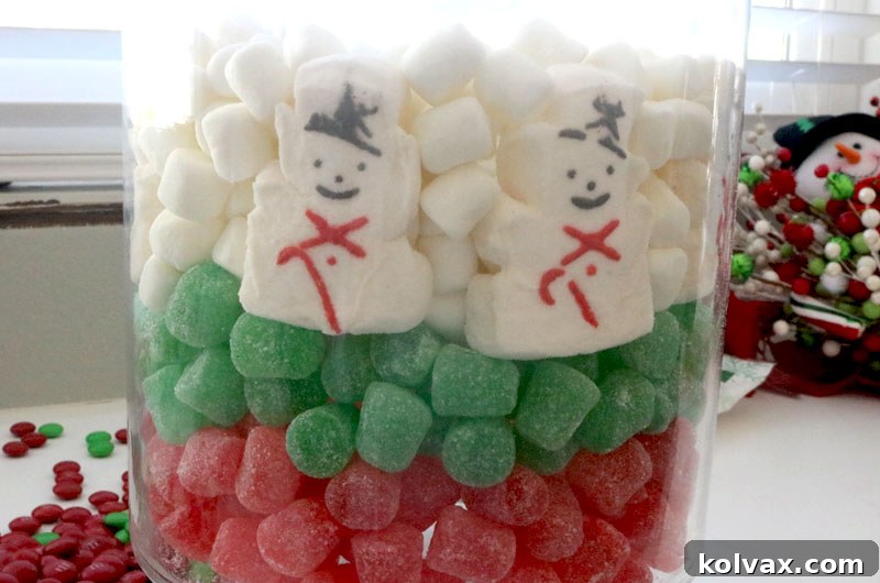 Cleverly filling gaps in the Peeps snowman layer with mini marshmallows, ensuring a full and cohesive candy display.