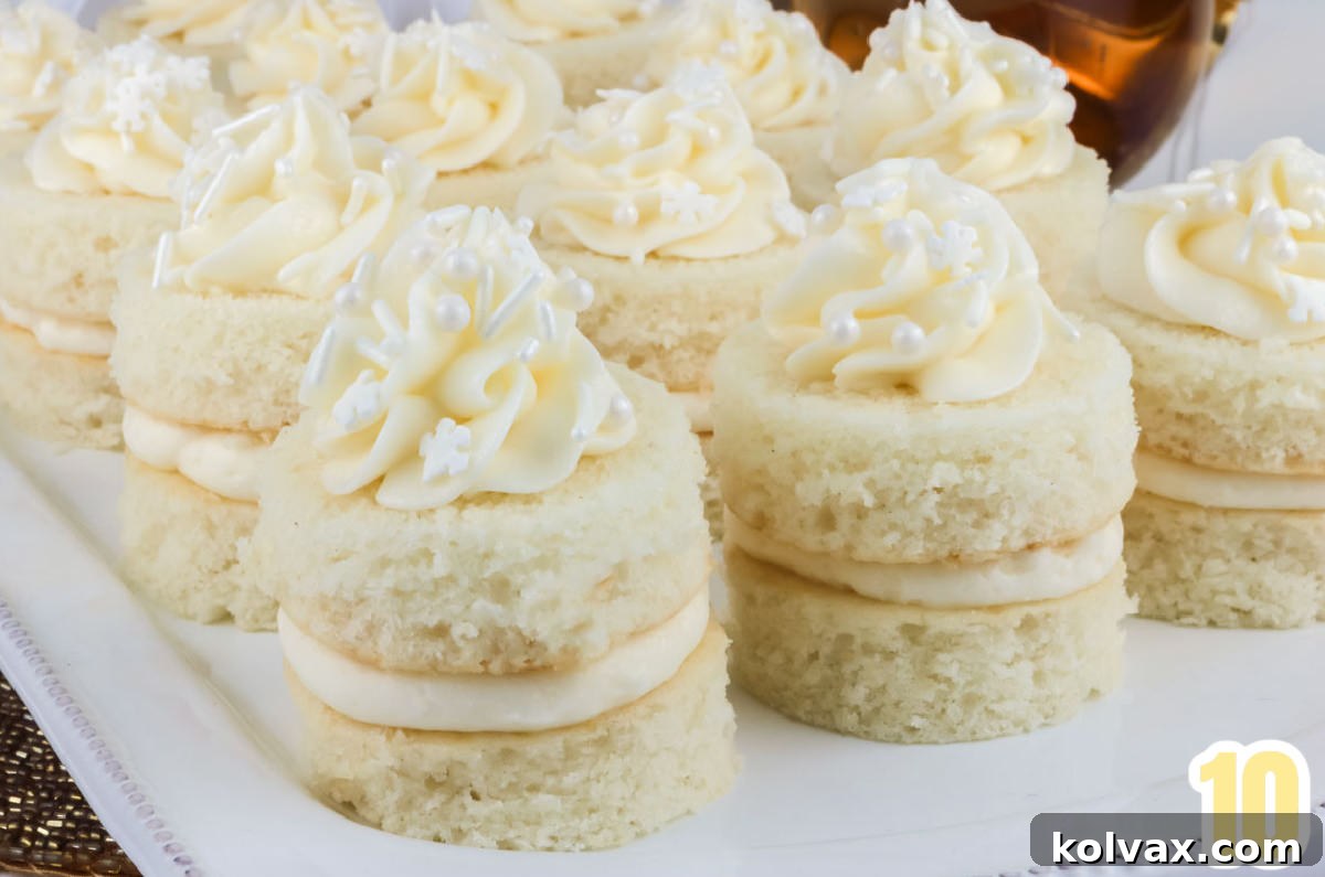 A dozen Champagne Cake Bites sitting on a white platter next to a glass of champagne.