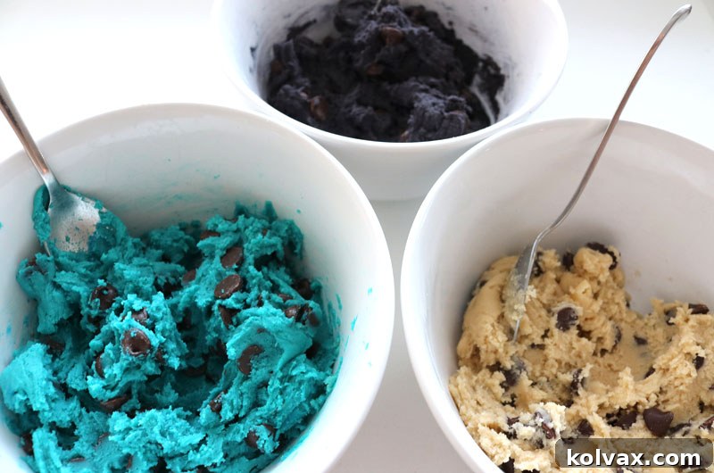 Cookie dough being colored blue and black using food coloring, with one portion remaining white, for Jacksonville Jaguars themed chocolate chip cookies. This step brings the team colors to life.