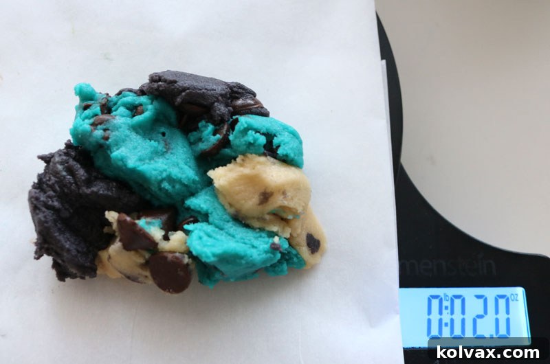 Assembling a ball of marbled cookie dough with blue, black, and white portions, measured to 2.0 oz on a food scale, for consistent Jacksonville Jaguars themed cookies.