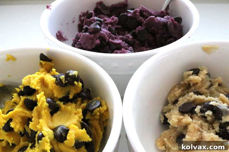 Cookie dough divided and expertly colored in vibrant purple, bright gold, and natural white, ready for chocolate chips.
