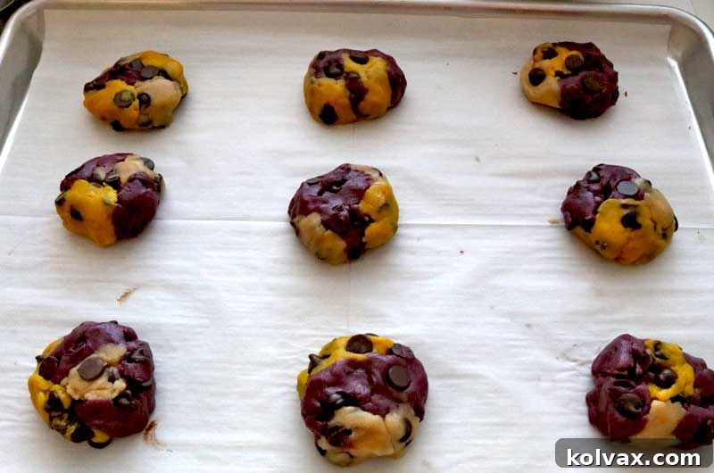 Minnesota Vikings Chocolate Chip Cookie dough balls, perfectly marbled in purple, gold, and white, arranged on a baking sheet, ready for the oven.