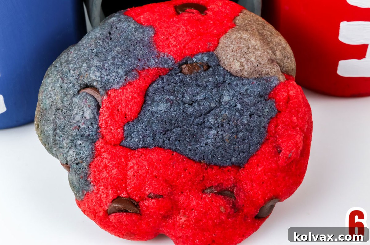 Closeup on a single New England Patriots Chocolate Chip Cookie laying on a white table, showing its marbled colors.