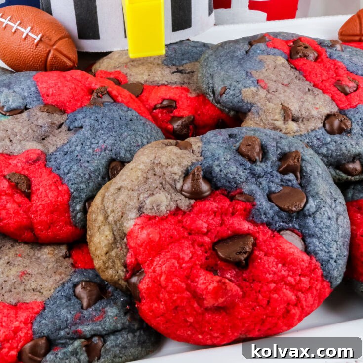 Closeup on a batch of New England Patriots Chocolate Chip Cookies sitting on a white plate in front of football decorations.