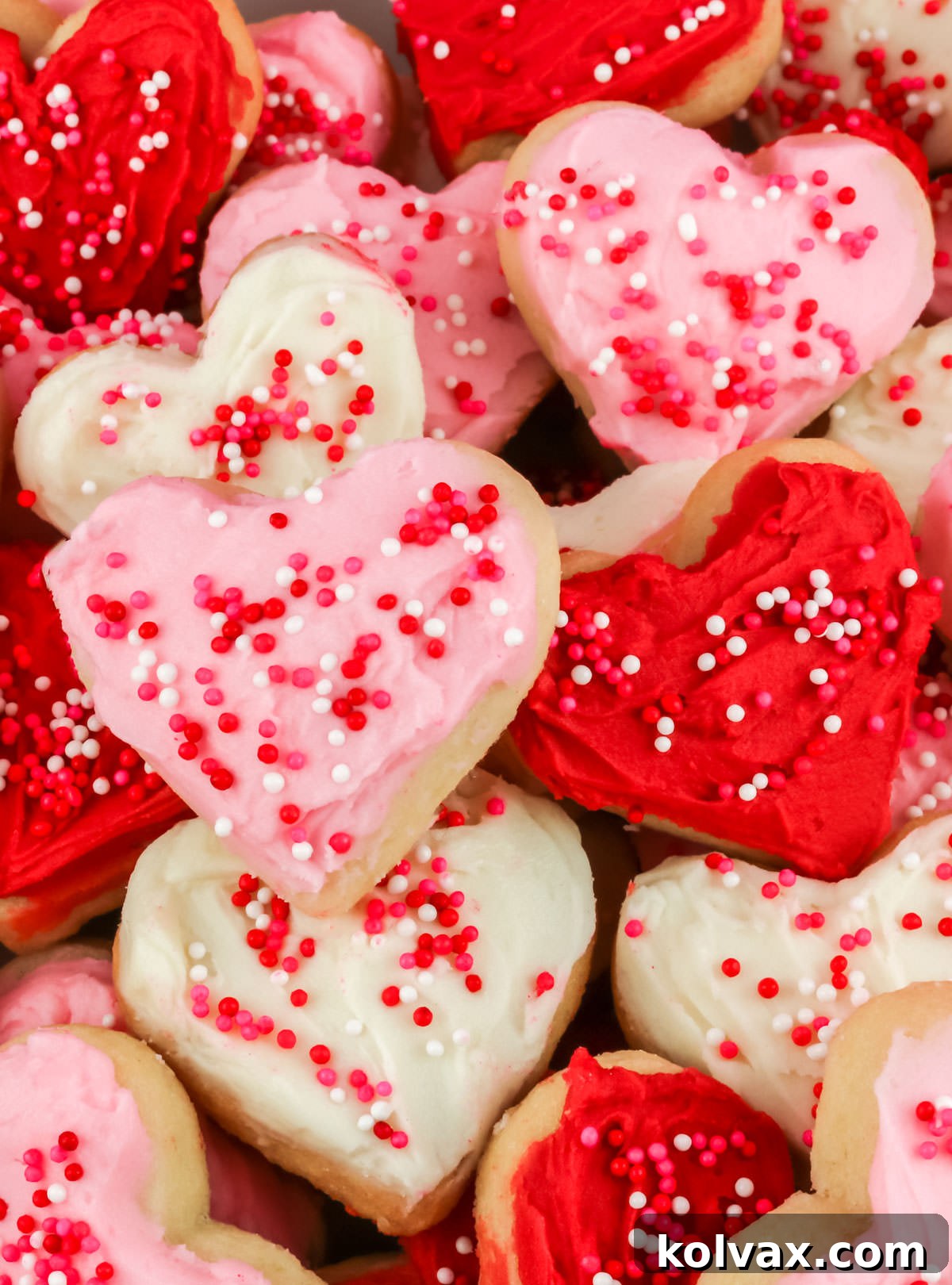 A captivating close-up on a perfectly arranged stack of heart-shaped Valentine's Frosted Sugar Cookies, showcasing layers of red, white, and pink frosting, ready for sharing.