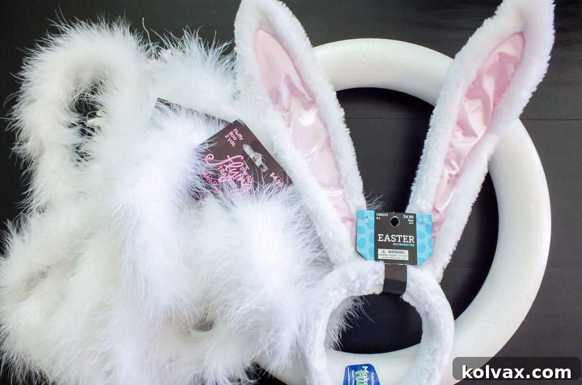 All the essential supplies for making a DIY Easter Bunny Wreath, neatly arranged: a round floral foam ring, an Easter bunny ear headband, and three fluffy white feather boas.