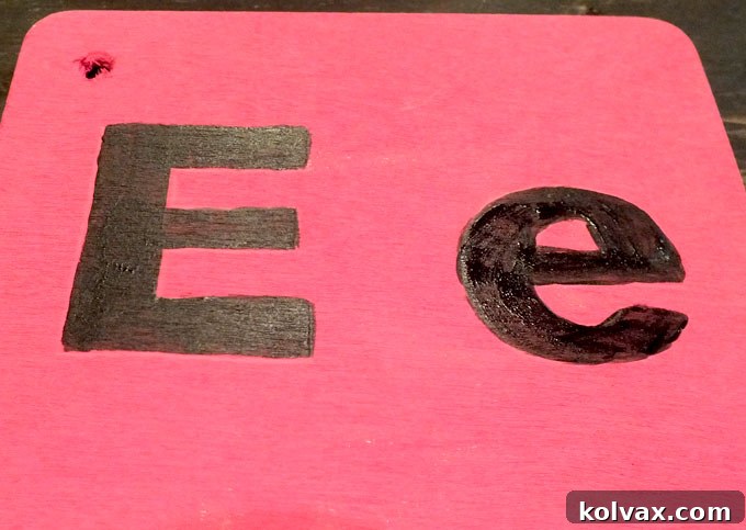 Applying chalkboard paint to the letter forms on wood blocks