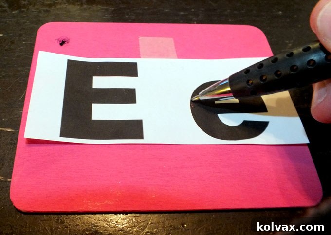 Tracing the letter outline with a ballpoint pen