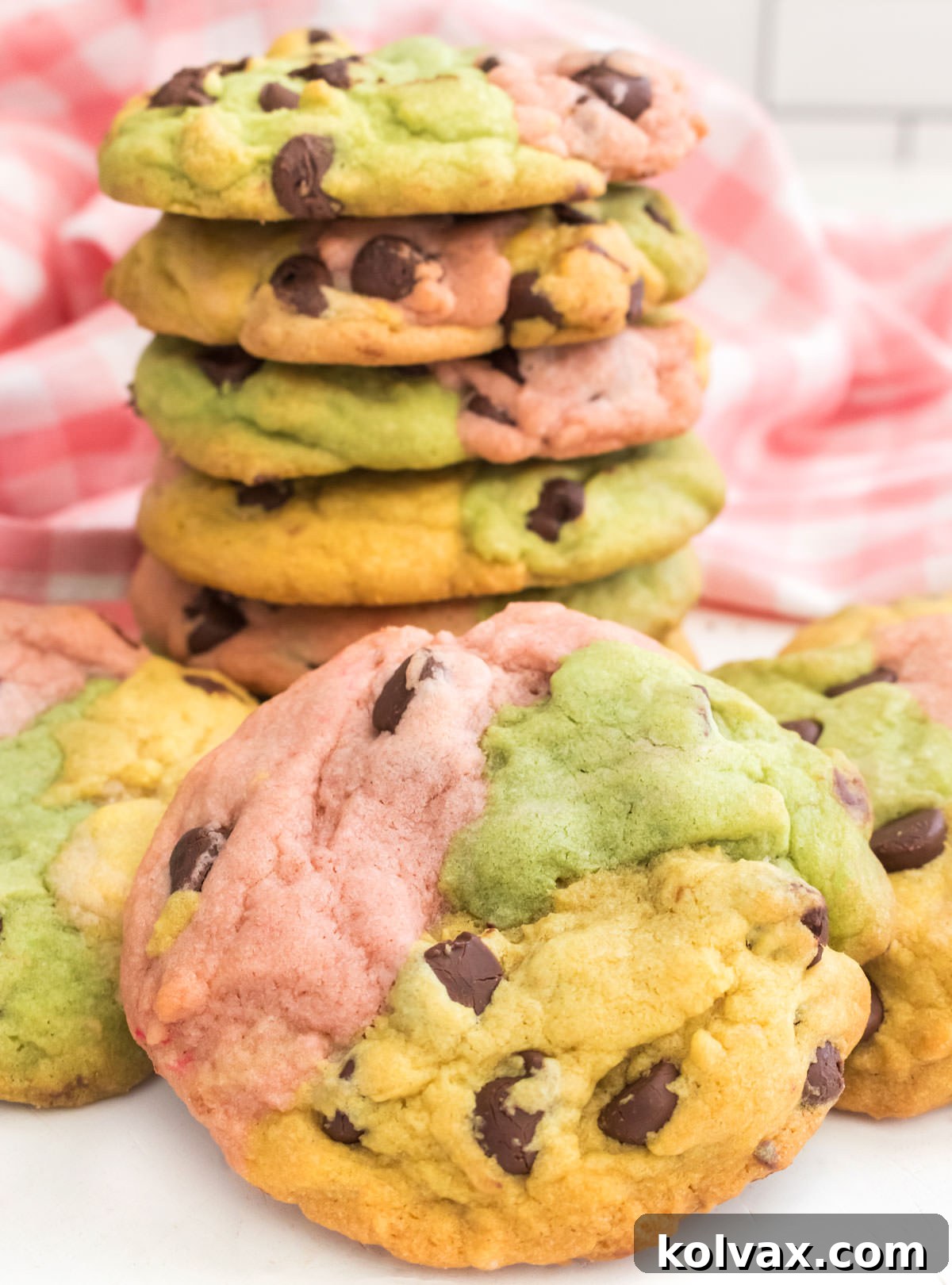 Close up on a stack of Spring Marble Chocolate Chip Cookies sitting on a white table surrounded by more cookies.