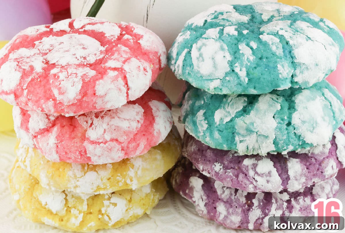 Two neatly stacked piles of vibrant Lemon Crinkle Cookies, in various pastel colors, resting on a white table linen, ready to be enjoyed.
