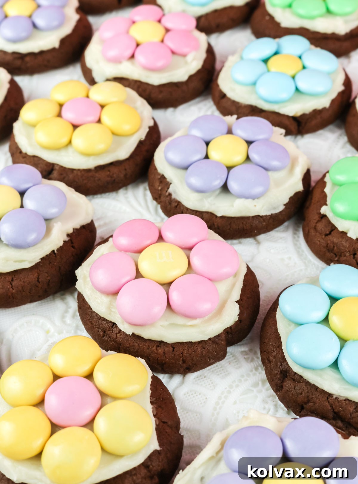 A captivating closeup view of perfectly aligned rows of M&M Flower Chocolate Cookies resting delicately on a crisp white table linen, highlighting their charming details.
