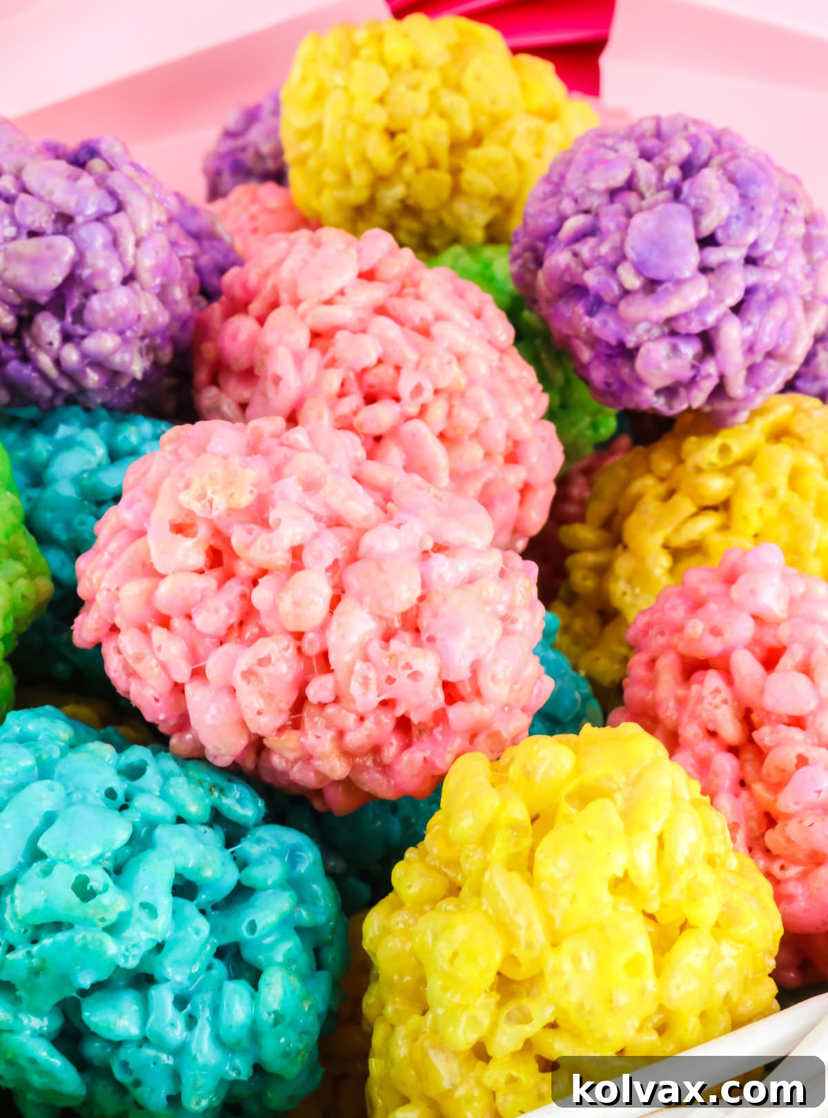 A close-up view of a charming white basket brimming with an array of vibrant, colorful Mini Rice Krispie Easter Eggs.