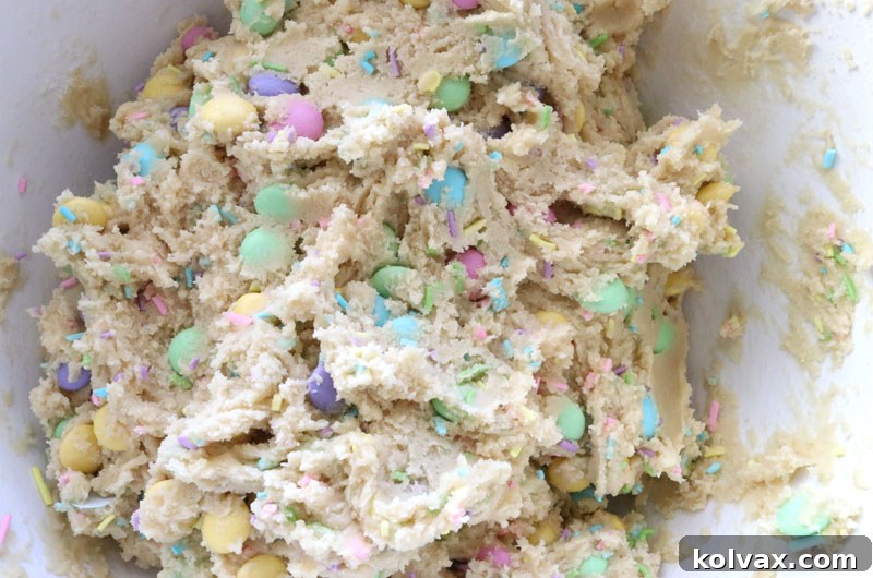 The fully mixed cookie dough for the Easter M&M Sugar Cookie Bars, with vibrant sprinkles and M&M's evenly distributed.