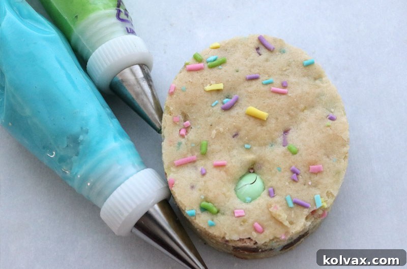 Decorating Easter M&M Sugar Cookie Bars with pastel-colored Best Buttercream Frosting.