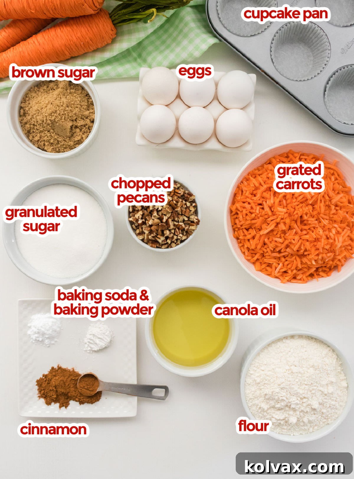 A vibrant flat lay of all the essential ingredients for Carrot Cake Cupcakes: flour, sugars, spices, fresh carrots, eggs, canola oil, and chopped pecans, ready for baking.