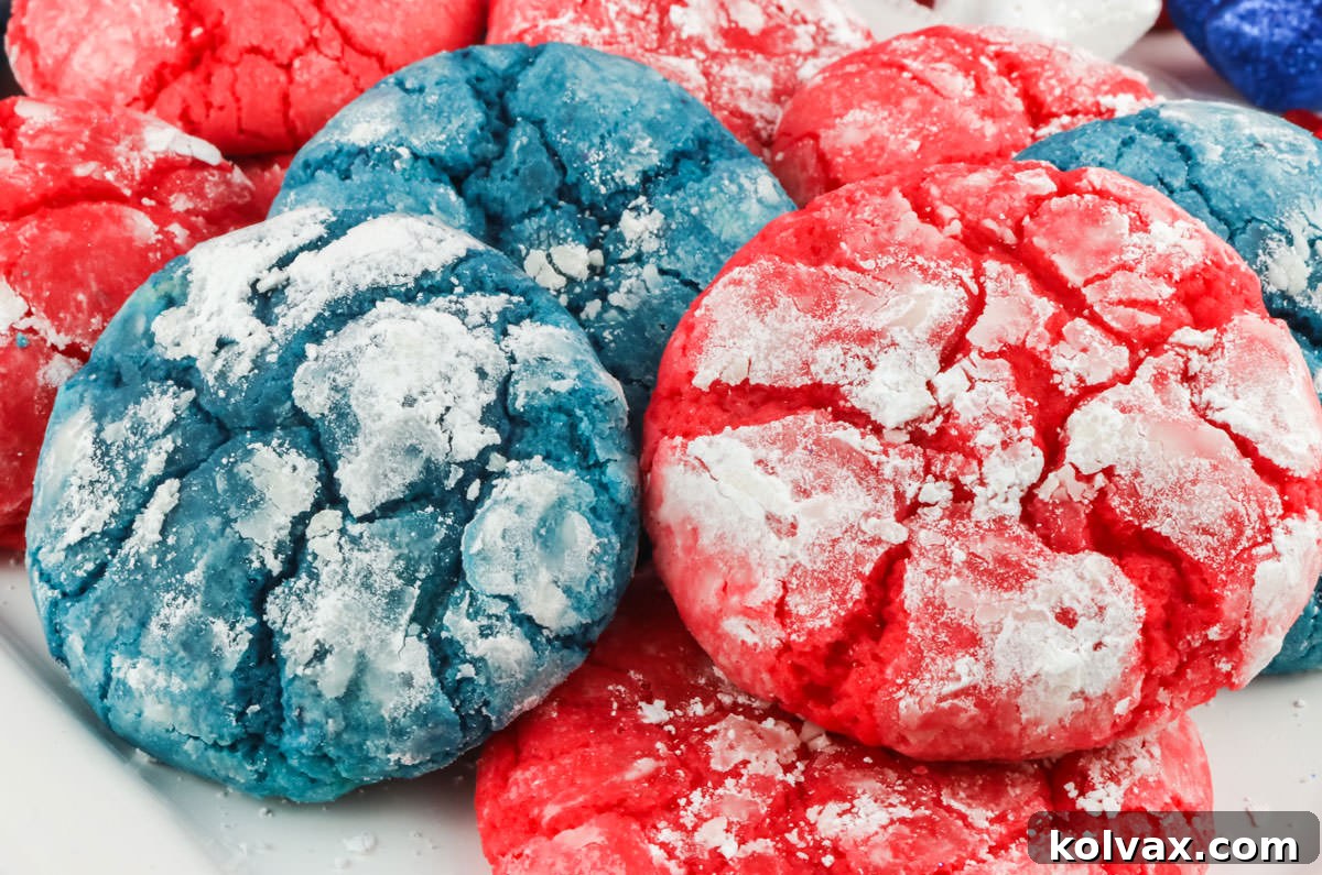 Closeup on a white serving platter holding a dozen vibrant Red White and Blue 4th of July Crinkle Cookies, dusted with powdered sugar.