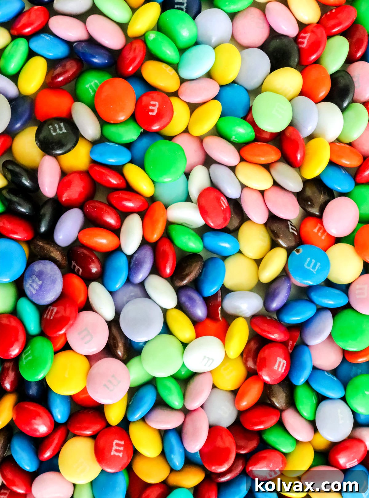 Every available color of M&M spread over a white table.