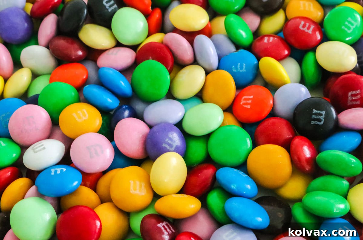 All the colors of M&M that are available for purchase spread out on a white table.