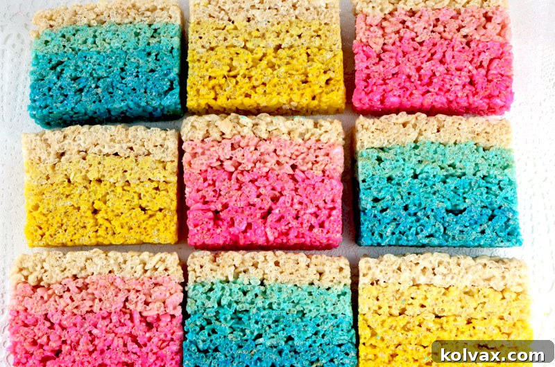 A vibrant display of colorful Rice Krispie Treats arranged like a rainbow, showcasing different hues created with food coloring.