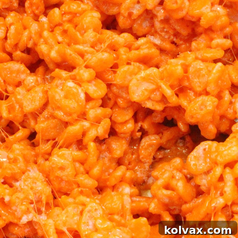Bright orange colored Rice Krispie Treats, ideal for autumn or Halloween.