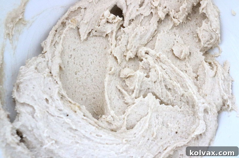 Creaming butter, granulated sugar, and brown sugar together until the mixture is light, fluffy, and perfectly combined, preparing the base for chocolate cookie dough.