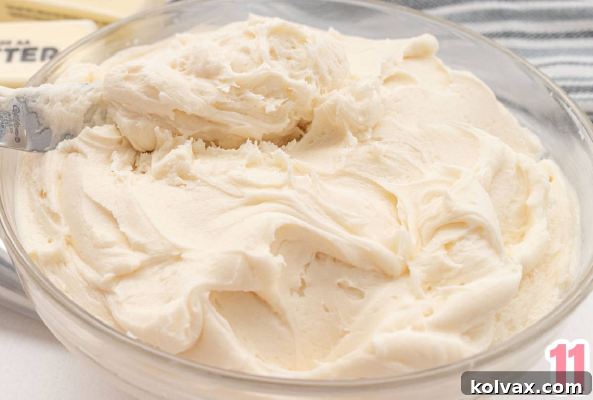 A delicious closeup of a glass bowl filled with rich, creamy homemade buttercream frosting, ready to be spread.