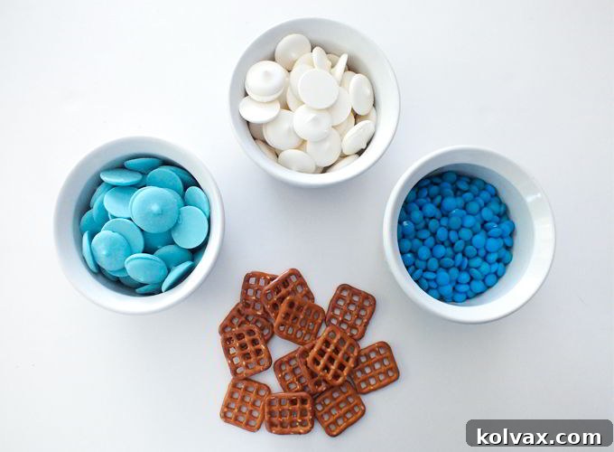 Snowflake Pretzel Bites Ingredients - A simple visual guide to all the sweet and salty components needed to create enchanting Disney Frozen-themed pretzel treats. Featuring white and blue candy melts, pretzel snaps, and M&M minis.