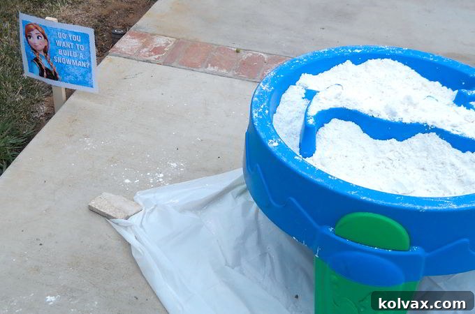 A 'Do You Want to Build a Snowman' activity station set up with DIY Play Snow and a protective cover underneath.