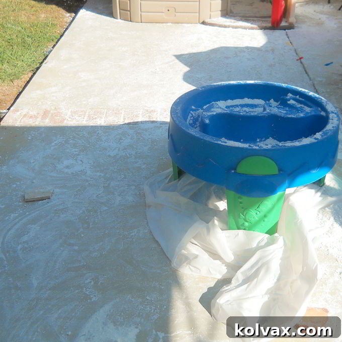 The aftermath of a DIY Play Snow party activity, showing cornstarch scattered on the floor despite a small tablecloth, highlighting the need for wider coverage or supervision.