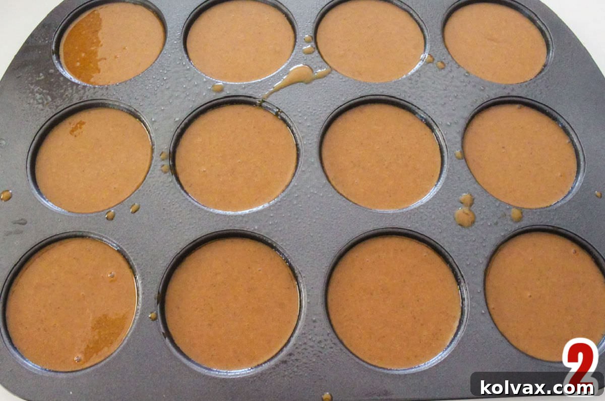 Overhead shot of a Wilton Whoopie Pie Cake Pan filled evenly with rich Gingerbread Cake Batter, ready for the oven.