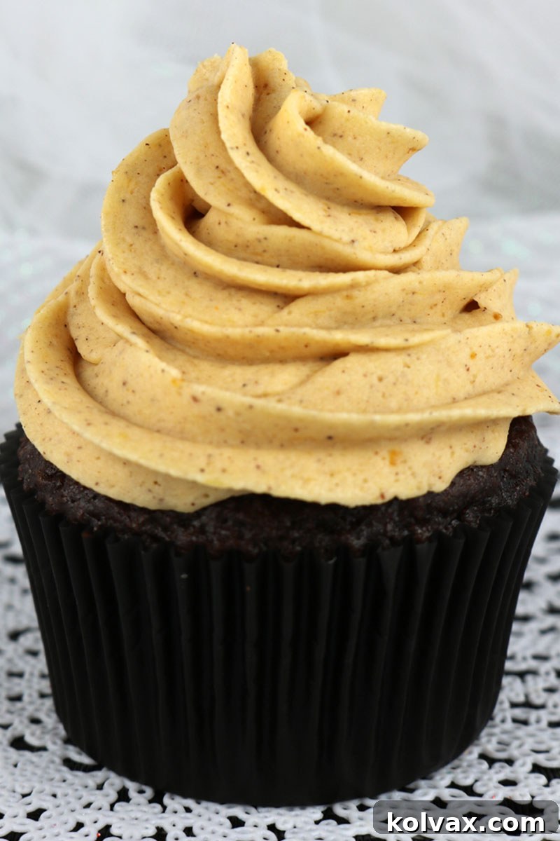 A close-up of rich, creamy pumpkin spice buttercream frosting, perfect for decorating fall cakes and cupcakes, showcasing its smooth texture.