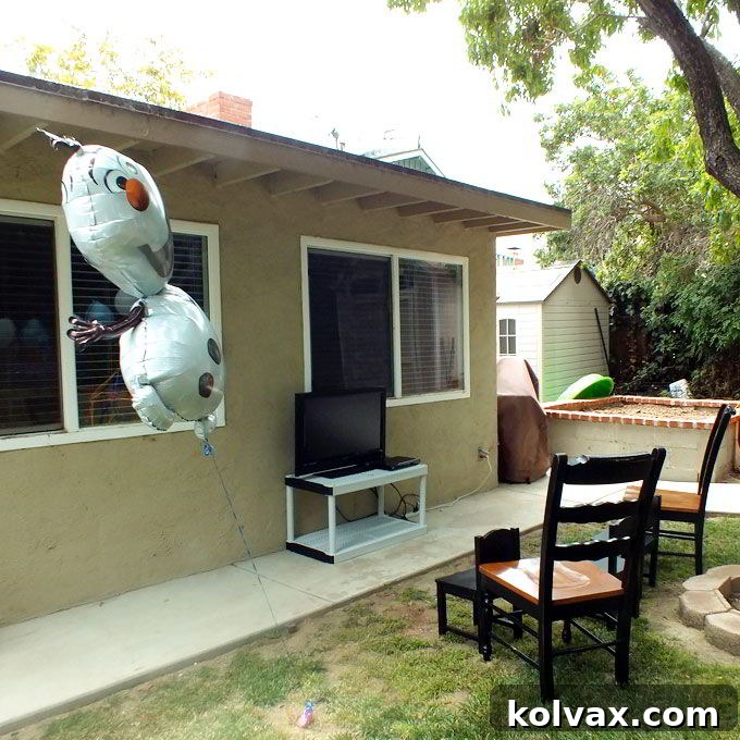 Setting up the Frozen Party Movie Watching Station with comfortable seating and a fun Olaf balloon.