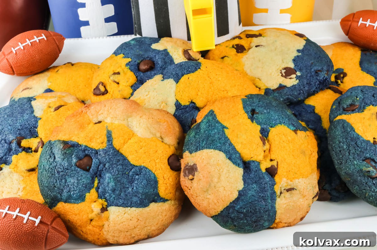 Closeup on a white serving platter filled with a batch of Los Angeles Rams Chocolate Chip Cookies surrounded by football party decorations.