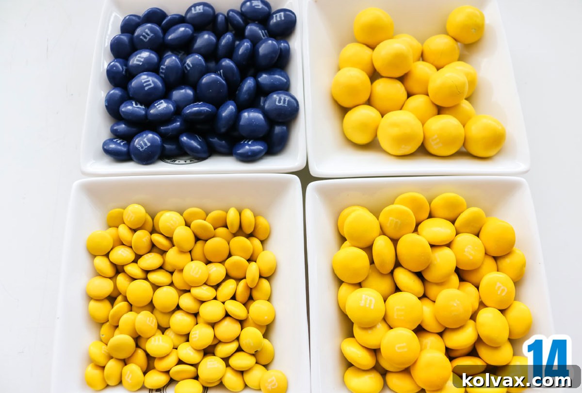 Four white ramekins filled with an assortment of blue and yellow M&M candies, ready for topping the Rams themed popcorn.