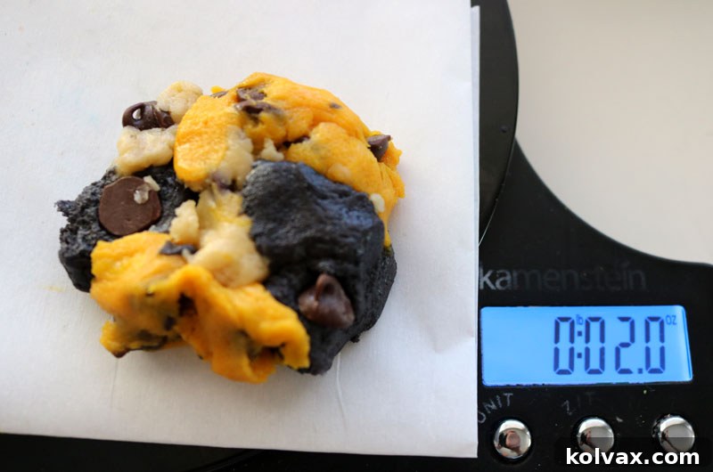 Close-up of a baker combining pieces of gold, black, and white cookie dough to form a single New Orleans Saints themed cookie ball.