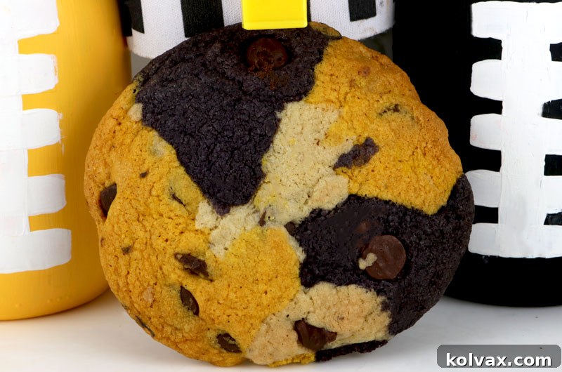 A plate of beautifully marbled New Orleans Saints Chocolate Chip Cookies, ready for serving at a game day party. Features black, gold, and white dough with chocolate chips.