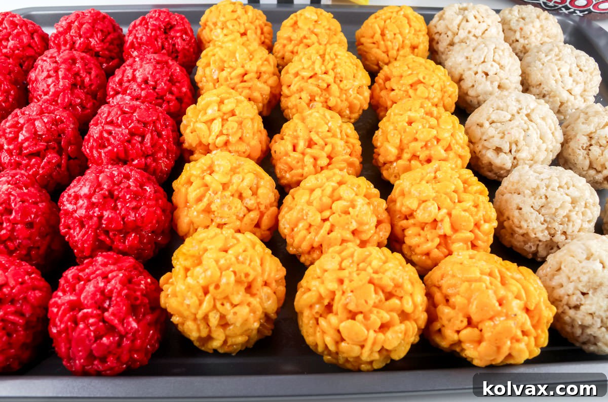 Chiefs Kingdom Krispies 8 Closeup on a cookie sheet filled with rows of Red, Gold and White Rice Krispie Bites.