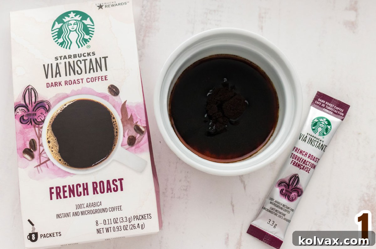 Instant coffee crystals dissolving in vanilla in a white ramekin.