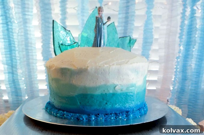 Stunning Disney Frozen Birthday Cake with Ombre Buttercream Frosting and a dazzling Hard Candy Frozen Fractal Ice Castle Cake Topper, set against a magical Frozen party backdrop. This beautiful cake was a highlight of our Frozen-themed celebration.