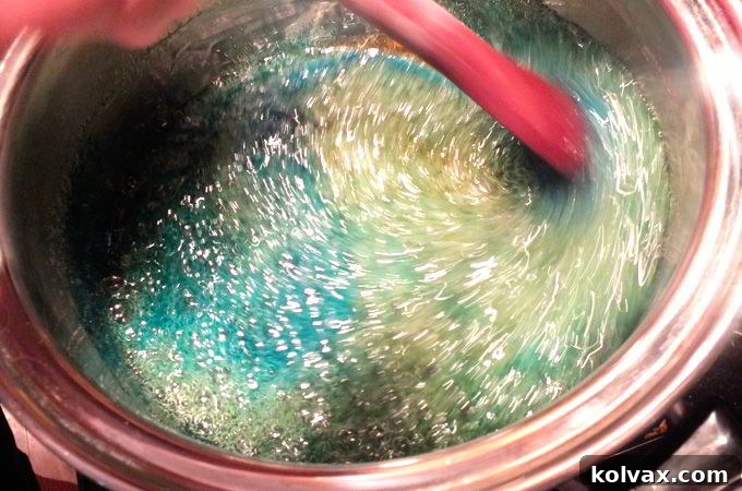 Adding a drop of Americolor Sky Blue Food Coloring to the hot hard candy mixture immediately after removing from heat, before the bubbles dissipate.