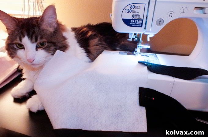 Sewing the black felt handles onto the top edge of the white felt bag pieces for durable attachment.
