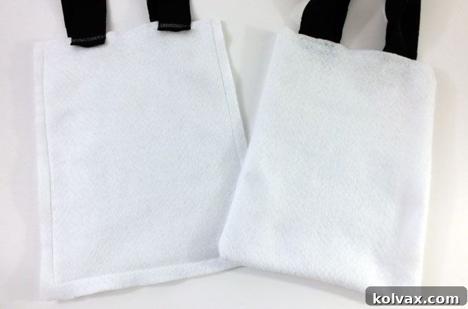 The completed white felt bag base, with handles securely attached, ready for Olaf's facial features.