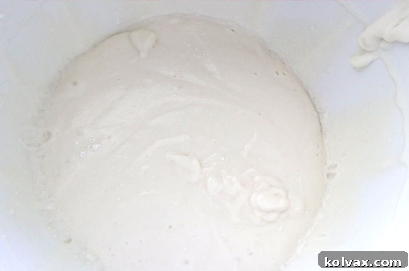 Preparing the pure white cake batter, showing the smooth consistency before adding chocolate chips.