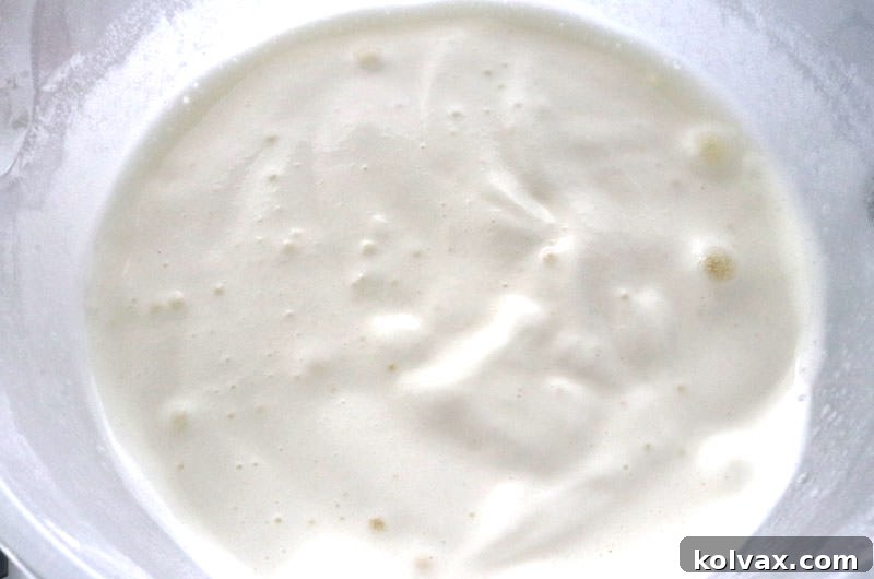 Angel Food Cake batter in a mixing bowl, showing its light and airy consistency before being portioned into cupcake liners.