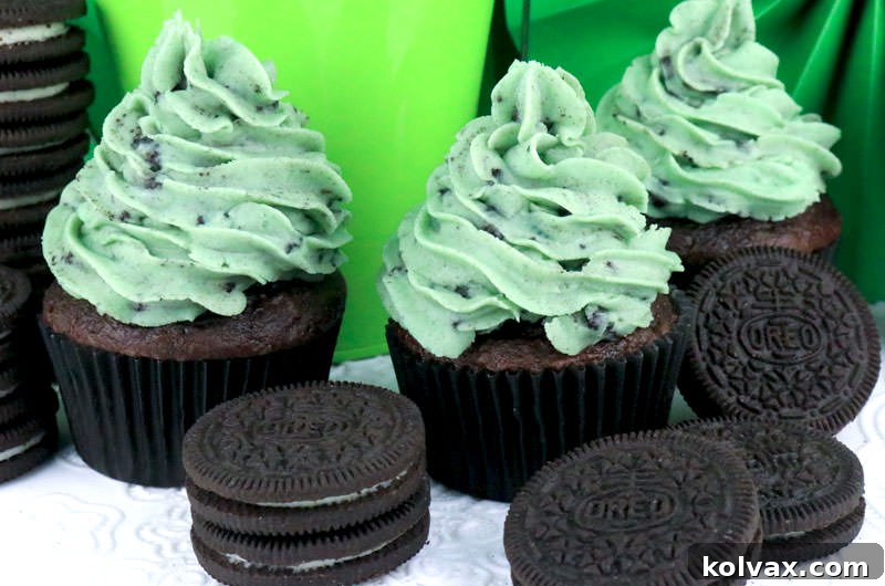 Lush Mint Oreo Buttercream Frosting on a cupcake, garnished with Oreo crumbs, showcasing its creamy texture and vibrant mint green color.
