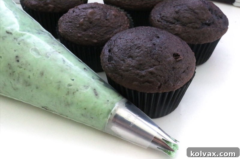 A scoop of creamy Mint Oreo Buttercream Frosting on a spatula, showcasing its volume and texture.
