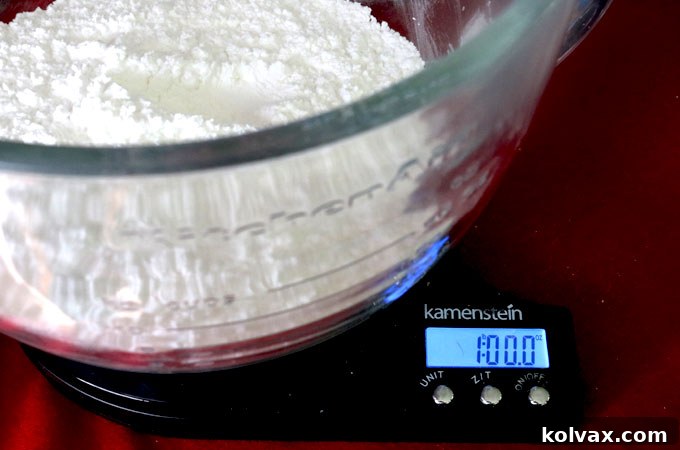 Measuring powdered sugar on a scale for buttercream frosting, highlighting precise ingredient preparation.