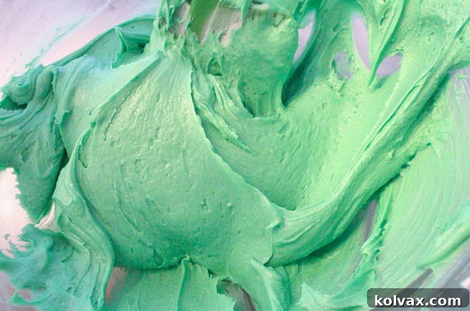 Tinting buttercream frosting with green food coloring to achieve a vibrant mint shade.